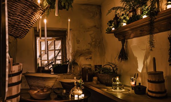 Photo of the Cottage Museum parlour lit by many candles.